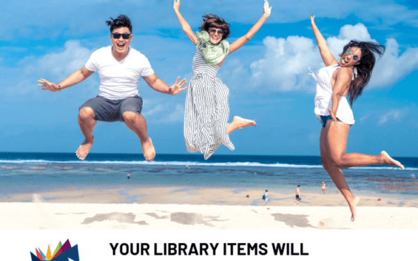 Three people jump in the air on a sandy beach with the ocean in the background under a clear blue sky.
