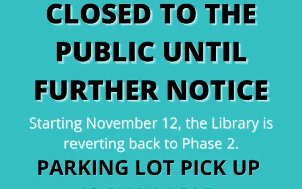 Sign stating the library is closed to the public until further notice, starting November 12, with parking lot pick up available as it reverts to Phase 2.